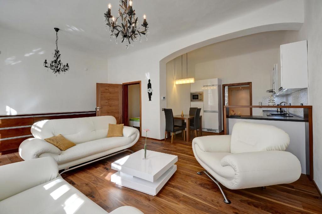 sala de estar con 2 sillas blancas y mesa en Historic Centre Apartments II, en Praga