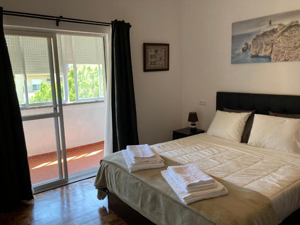 een slaapkamer met een bed met twee handdoeken erop bij FAMILY APARTMENT LISBON-ESTORIL in Estoril