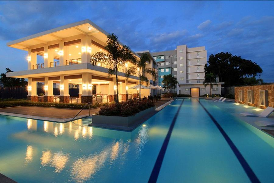 uma villa com piscina em frente a um edifício em Downtown Davao City 2 BR Condo with pool and gym em Dávao