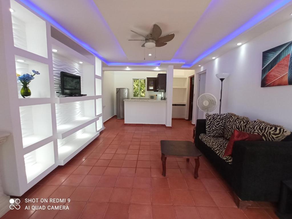 a living room with a couch and a ceiling with blue lights at Sosua Suites Condos in Sosúa