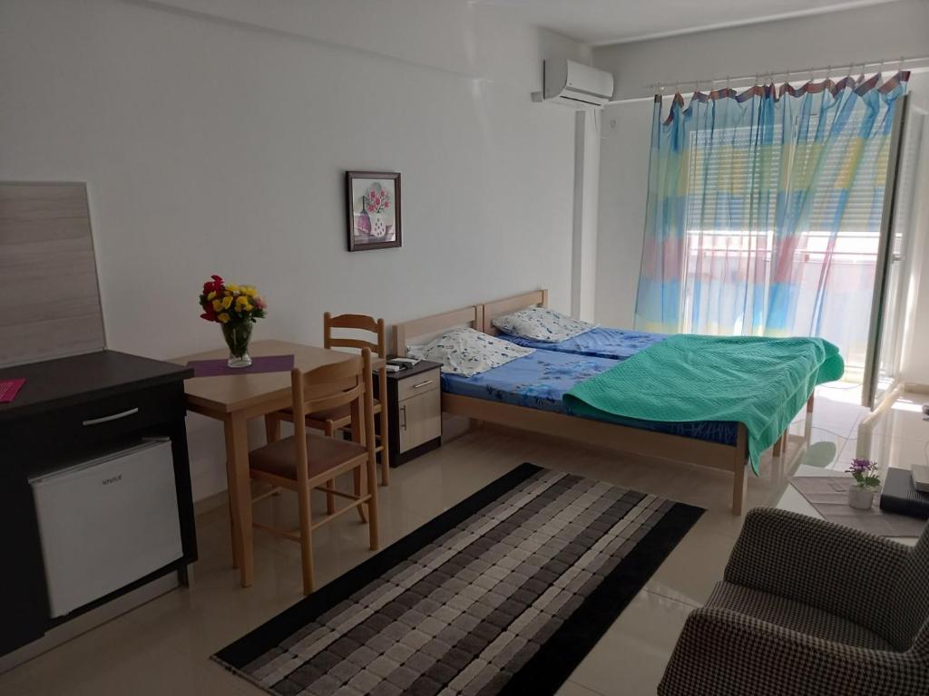 a small bedroom with a bed and a desk and a table at Apartman Savić in Bar