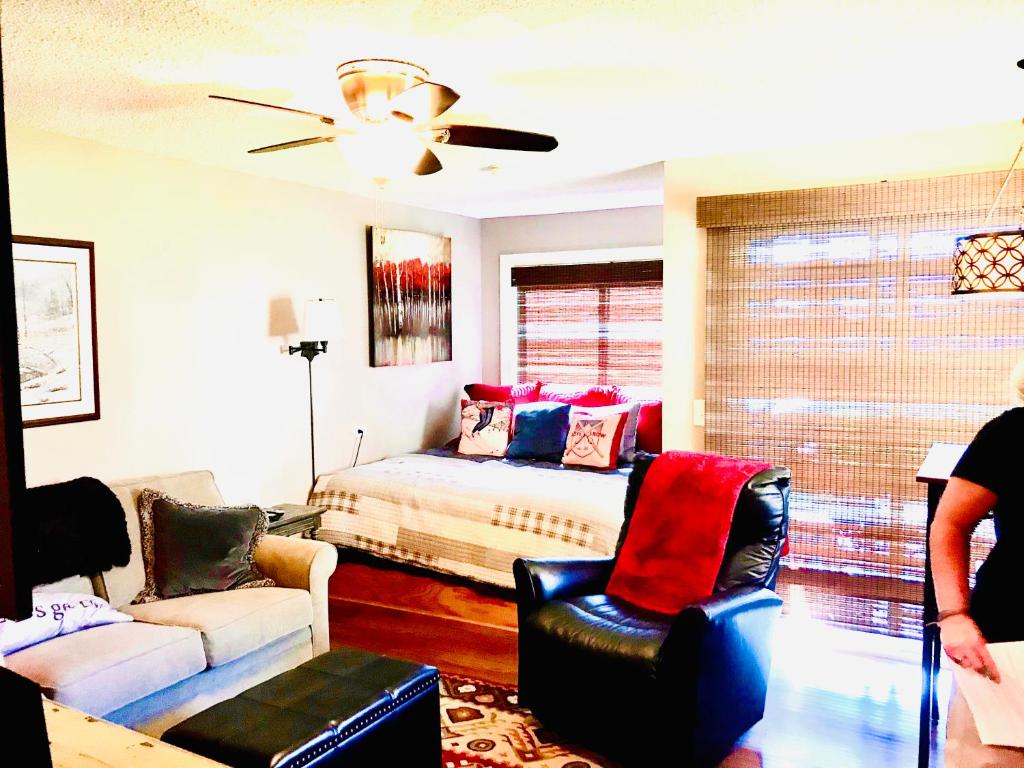 a bedroom with a bed and a couch and chairs at Beech Mountain Cozy Condo in Beech Mountain