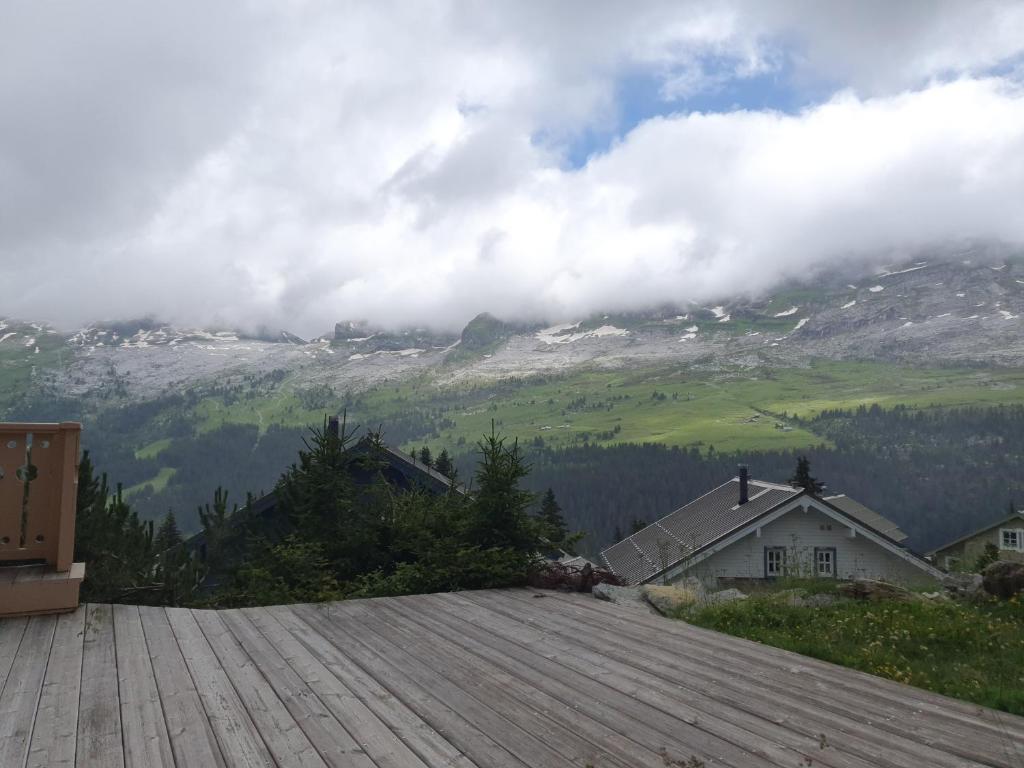 a wooden deck with a view of a mountain at MAGNIFIQUE APPARTEMENT AVEC TERRASSE et VUE IMPRENABLE SUR LE CIRQUE DE FLAINE, 2 chambres et coin montagne, 6 personnes in Flaine