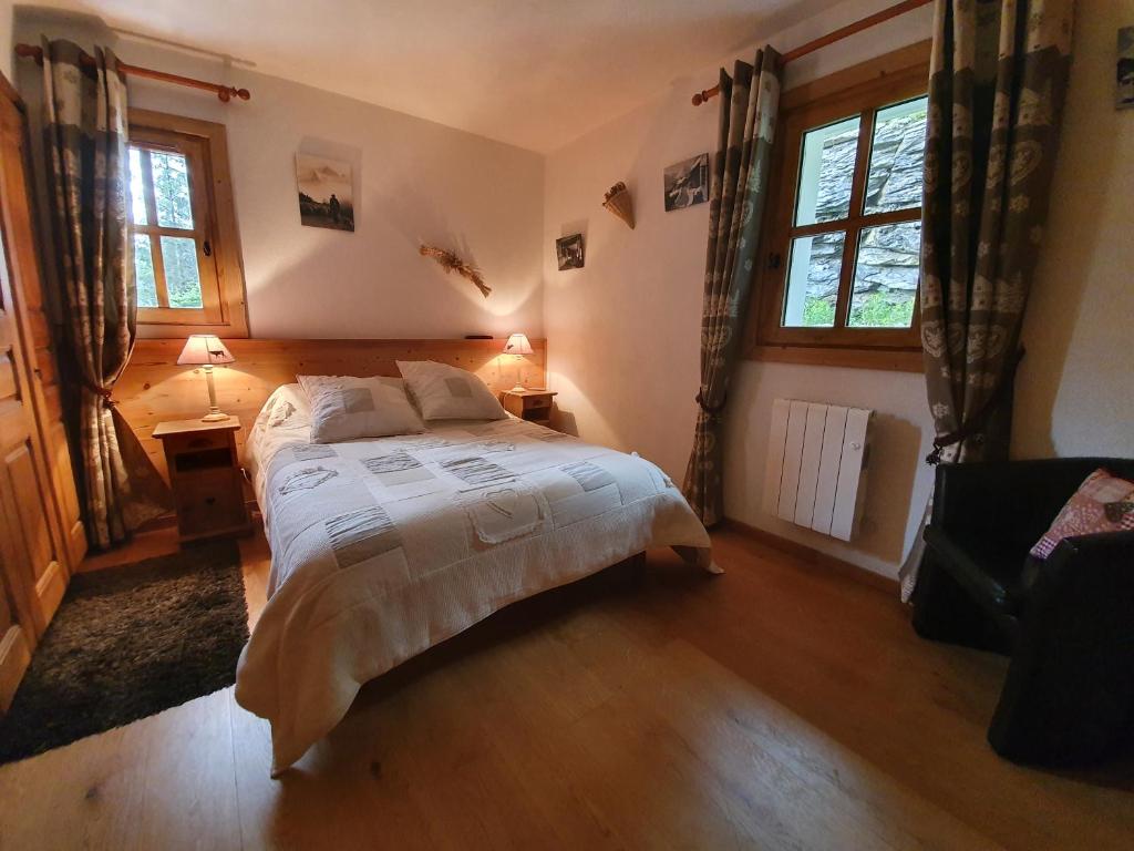 a bedroom with a bed and two windows at MAGNIFIQUE APPARTEMENT AVEC TERRASSE et VUE IMPRENABLE SUR LE CIRQUE DE FLAINE, 2 chambres et coin montagne, 6 personnes in Flaine