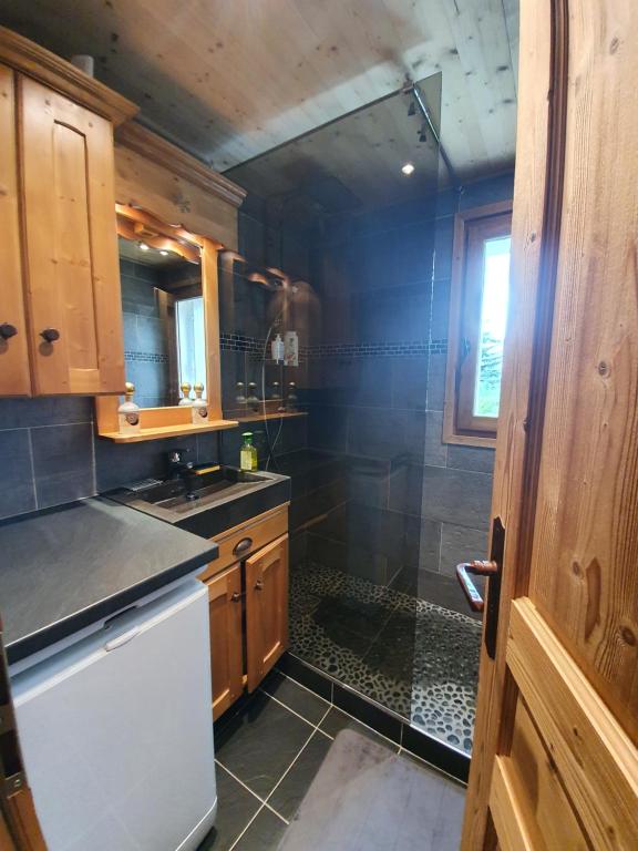 a kitchen with a shower and a sink and a refrigerator at MAGNIFIQUE APPARTEMENT AVEC TERRASSE et VUE IMPRENABLE SUR LE CIRQUE DE FLAINE, 2 chambres et coin montagne, 6 personnes in Flaine