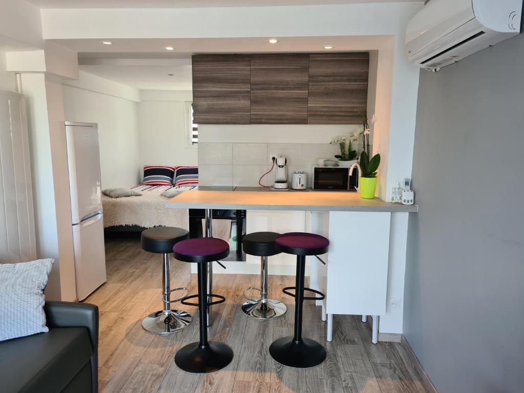 a kitchen with a counter and stools in a room at spacieux studio dans le Beaujolais in Saint-Georges-de-Reneins