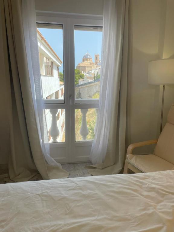 1 dormitorio con cama y ventana con vistas en AlteaWohnung - Life: Pueblo, Iglesia, Pool, Montana, en Altea