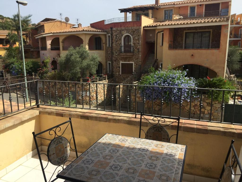 un balcone di una casa con tavolo e sedie di Tuffarsi nel Paradiso a Villasimius