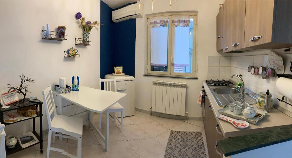 una pequeña cocina con mesa y fregadero en Monolocale centro storico, en Enna