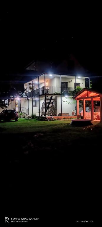 a large white building with a staircase in front of it at night at B&B House in Mestia