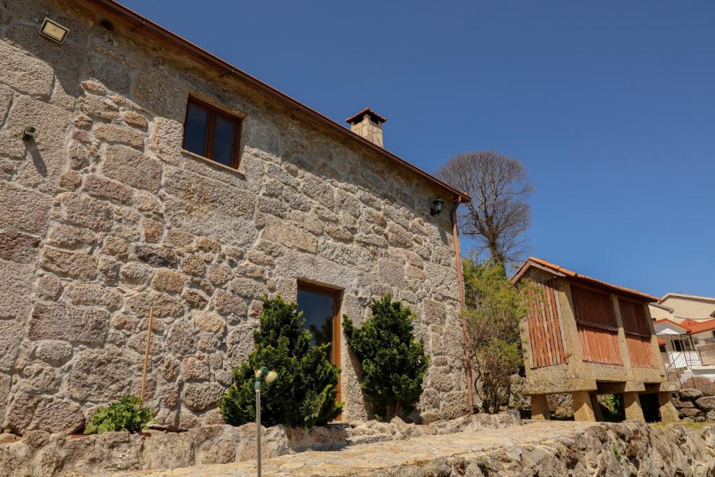 a stone house with a stone wall at Casa das Lages in Viariz