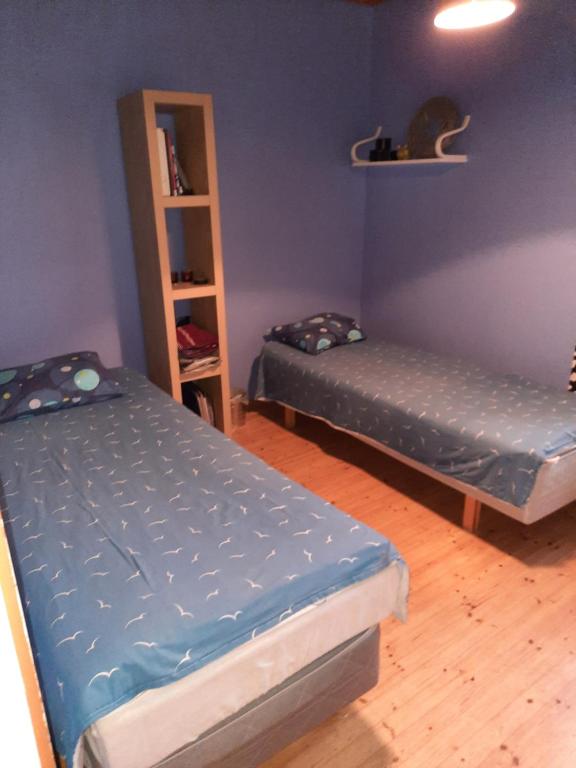 Pokój z 2 łóżkami i półką na książki w obiekcie vierashuone w mieście Oulu