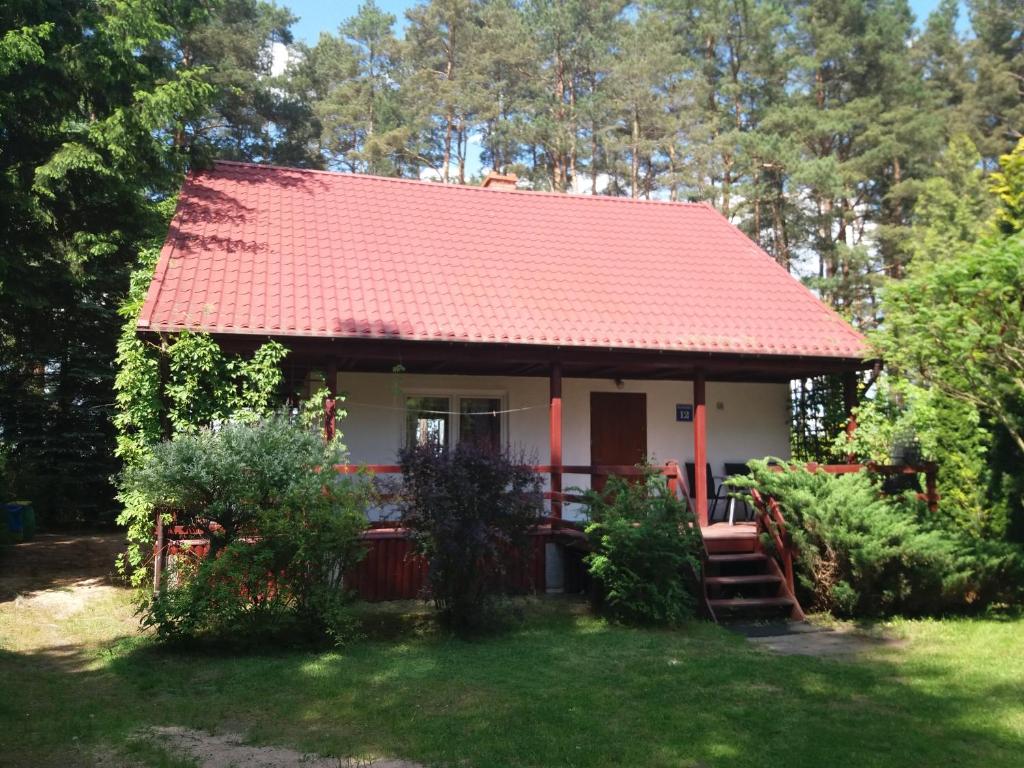 mały biały dom z czerwonym dachem w obiekcie Dom pod Sosnami w mieście Narty