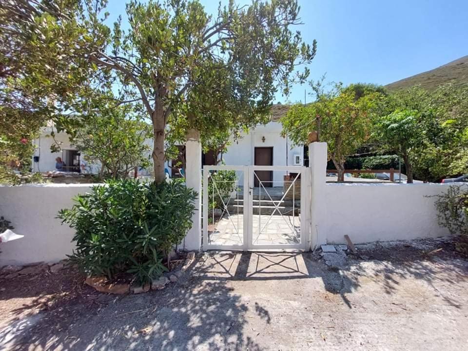 a white fence with a gate in front of a house at Dimitrios in Pórto Káyio