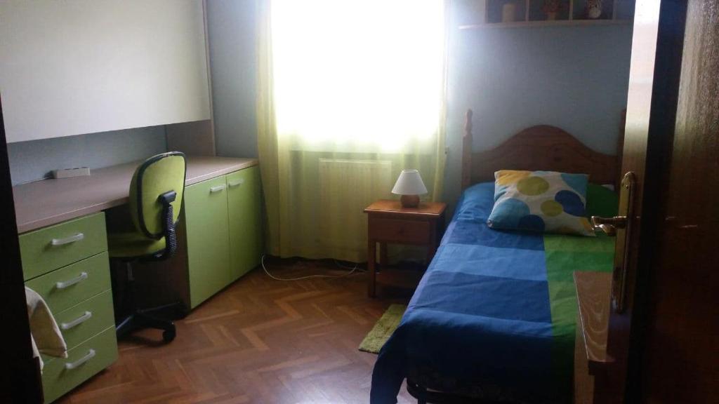 1 dormitorio con cama, escritorio y silla en Habitación para mujer, en Guadalajara