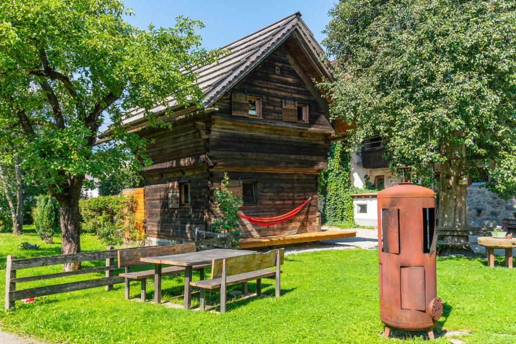 Cabaña de madera con mesa de picnic frente a una casa en Holzblockhäuser Fam. Schabus, en Hermagor