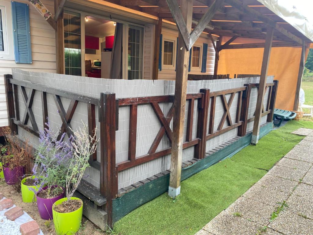 a wooden fence in front of a house at Mobilehome 3 chambres curistes camping piscine in Saint-Paul-lès-Dax