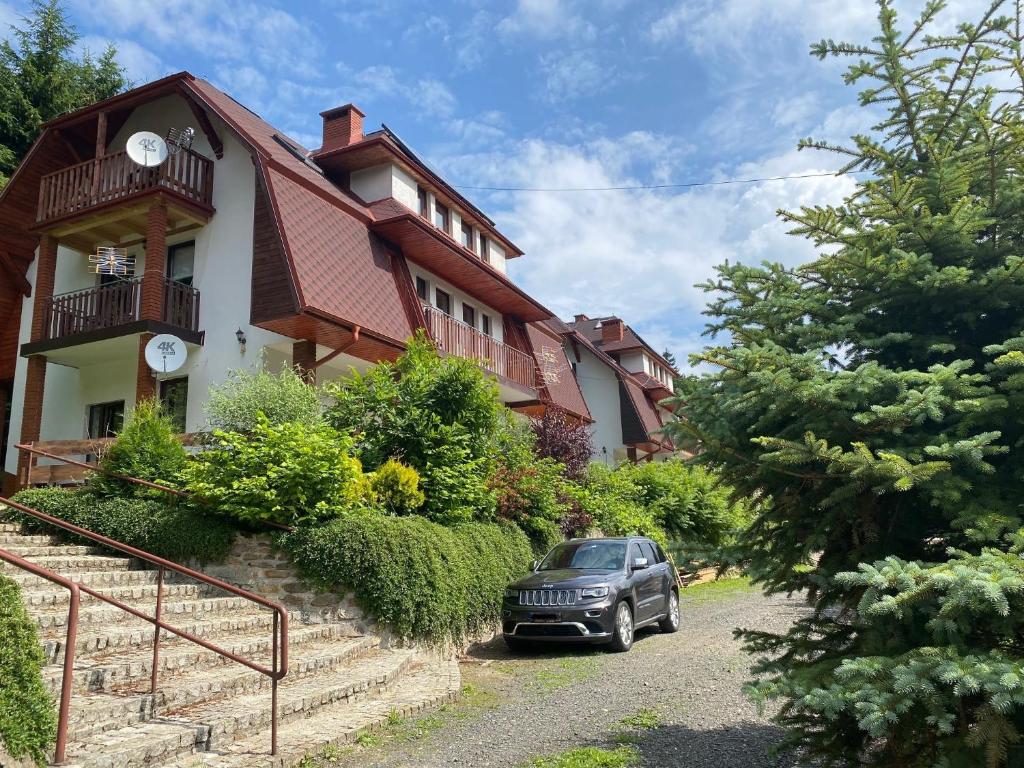 a car parked in front of a house at Apartament Artemida Kletno in Stronie Śląskie