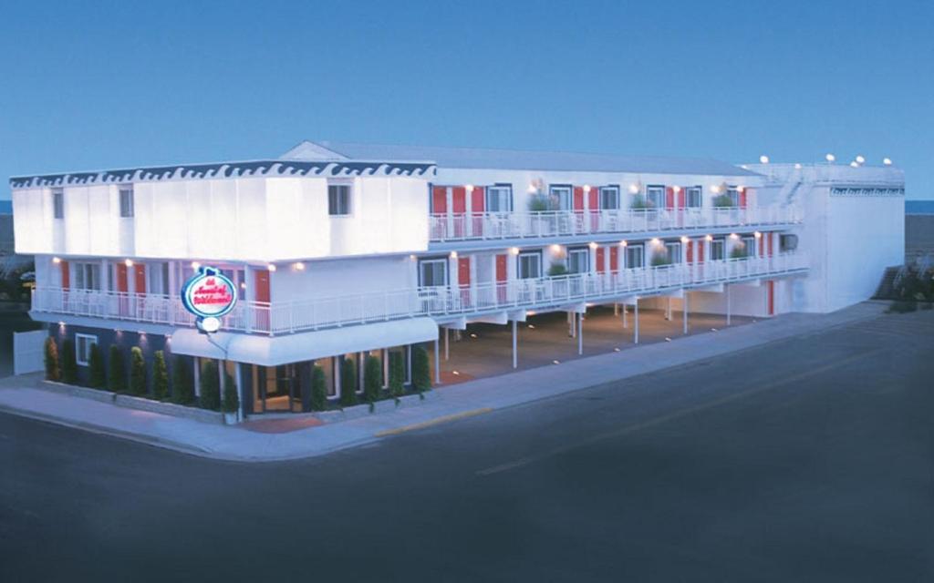 a large white building with red doors and windows at Heart of Wildwood Motel in Wildwood