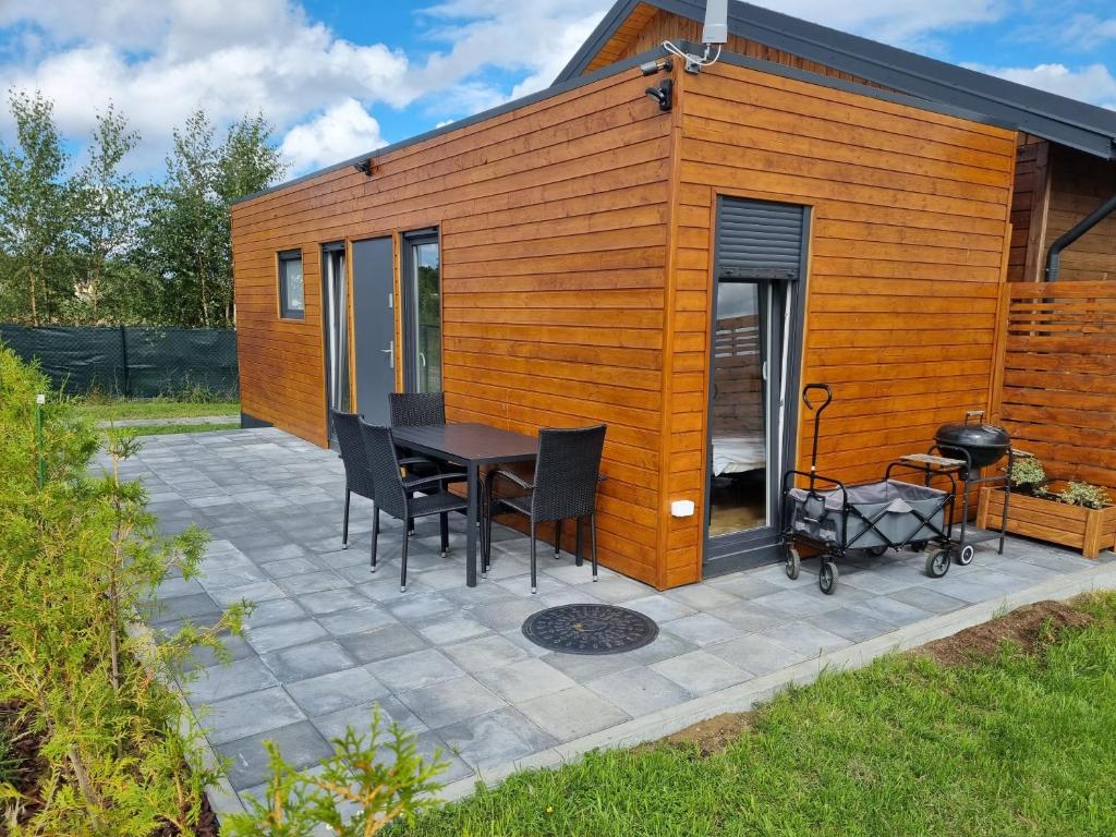 a tiny house with a table and chairs on a patio at Gąski domek 800m od morza in Gąski