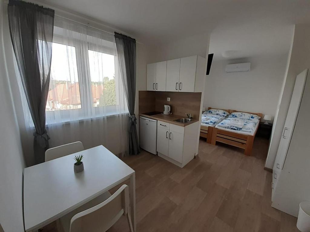 a room with a kitchen and a bed and a table at Valen apartmány Valtice in Valtice