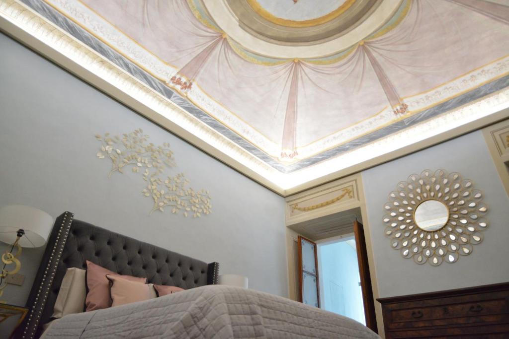 sypialnia z sufitem z łóżkiem i lustrem w obiekcie Campana Suites w mieście Bibbiena