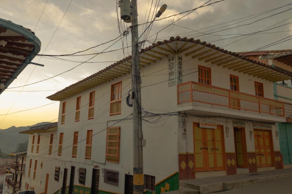 a white building with orange doors on a street at Hotel Felicina in Jeric&oacute;