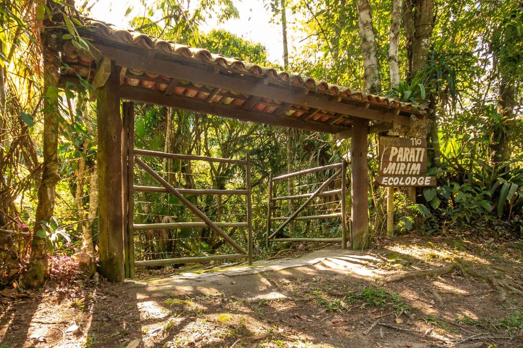 uma entrada para uma floresta com um portão e uma placa em EcoLodge Paraty em Paraty