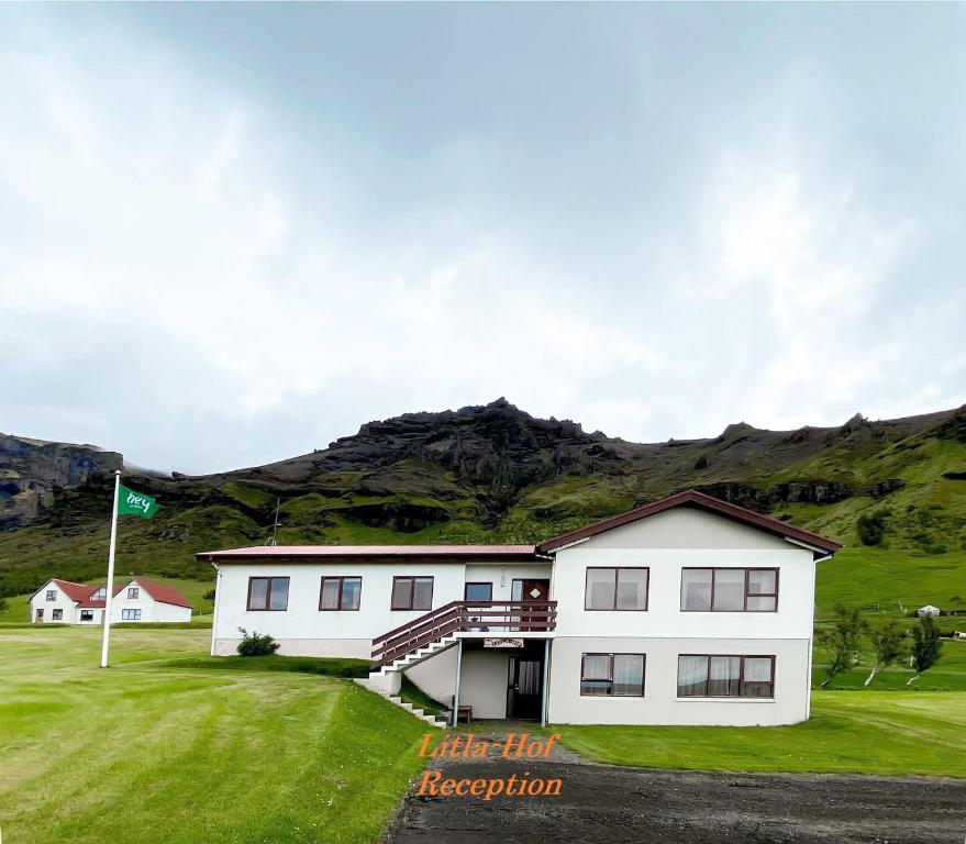 een wit huis met een berg op de achtergrond bij Litla-Hof Guesthouse in Hof