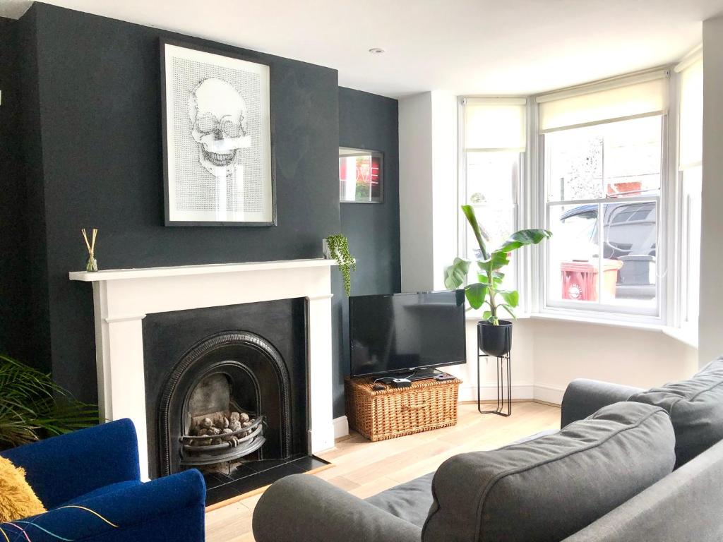 a living room with a fireplace and a tv at Boutique City Centre Home in Chichester