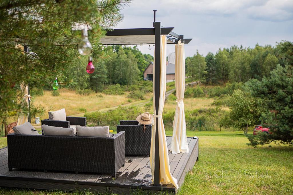 un gazebo con un divano e delle tende su un ponte di Oaza Spokoju Siecino - Mońka a Chlebowo