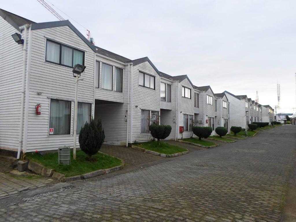 a row of houses are lined up on a street at Apart Hotel Fx in Puerto Montt