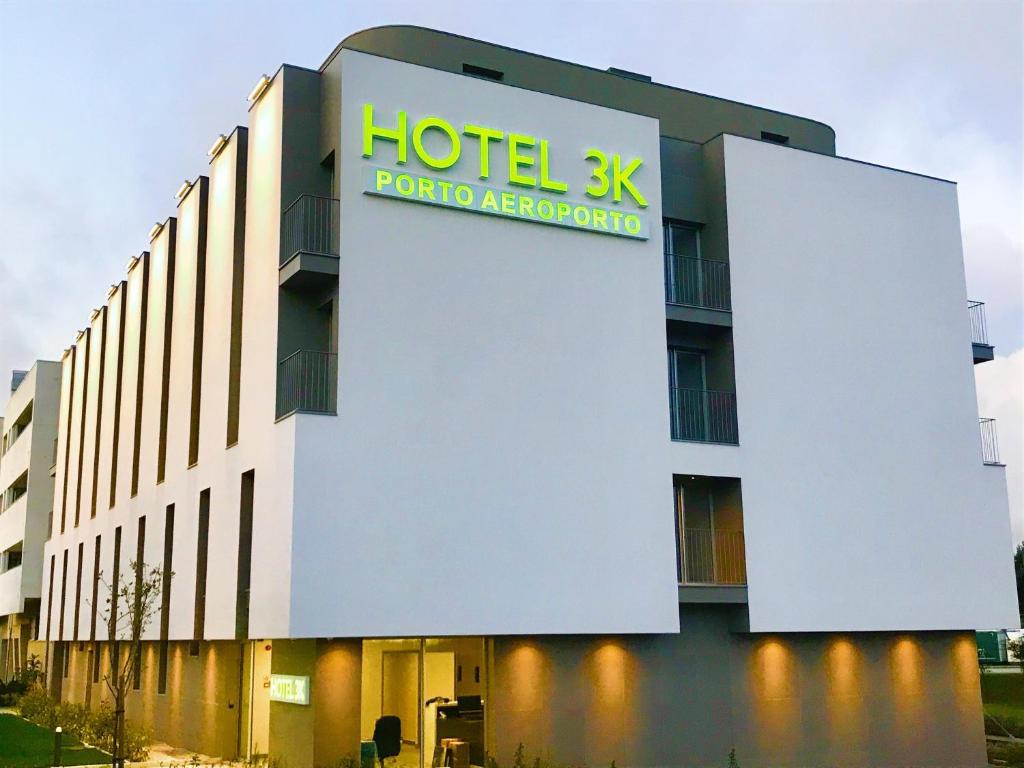 un edificio de hotel kmx con un cartel en él en Hotel 3K Porto Aeroporto en Maia