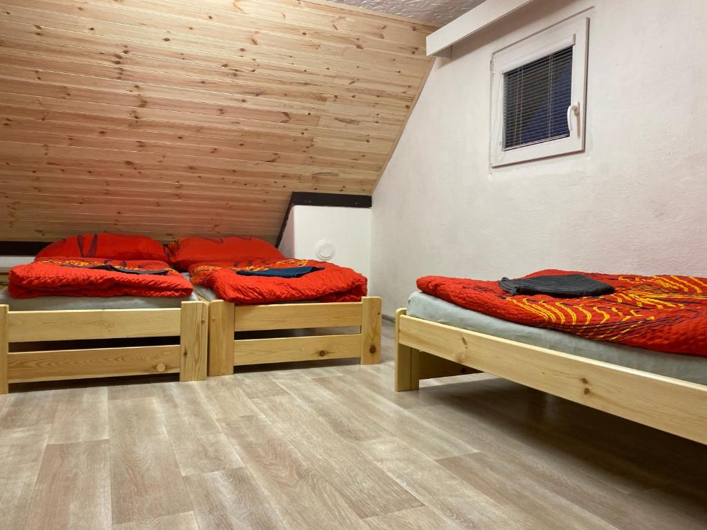 two beds in a room with wooden walls at Chata v Beskydech Trojanovice in Trojanovice