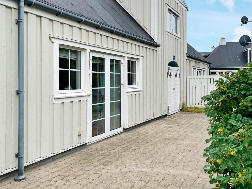 un garaje blanco con puertas y una valla en Apartment Ringkøbing CXXV, en Ringkøbing