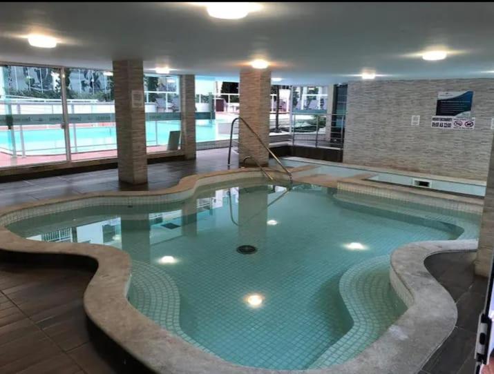 ボンビーニャスにあるApartamento Maravilhoso,condominio com piscina aquecida coberta e mais 2 externas.の大きな建物内の大きなスイミングプール