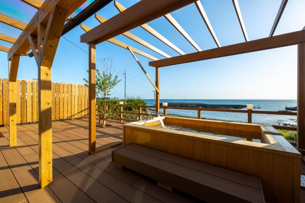 a hot tub on a deck with a view of the ocean at StellaStoria HAYAMA Seaside house with open-air bath in Hayama