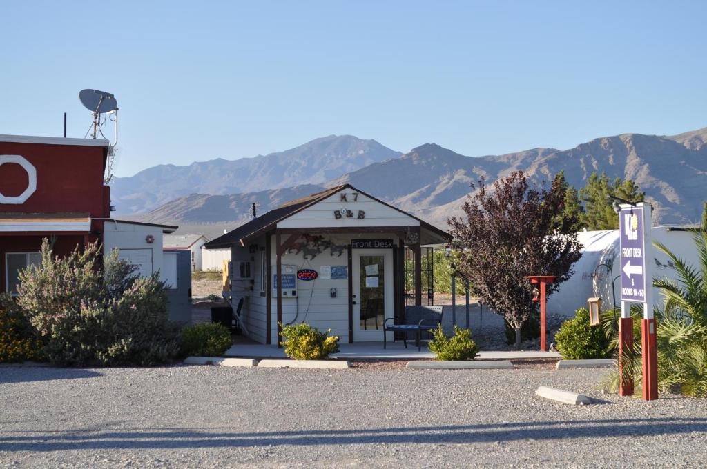 Un petit bâtiment blanc avec des montagnes en arrière-plan dans l'établissement K7 Bed and Breakfast, à Pahrump