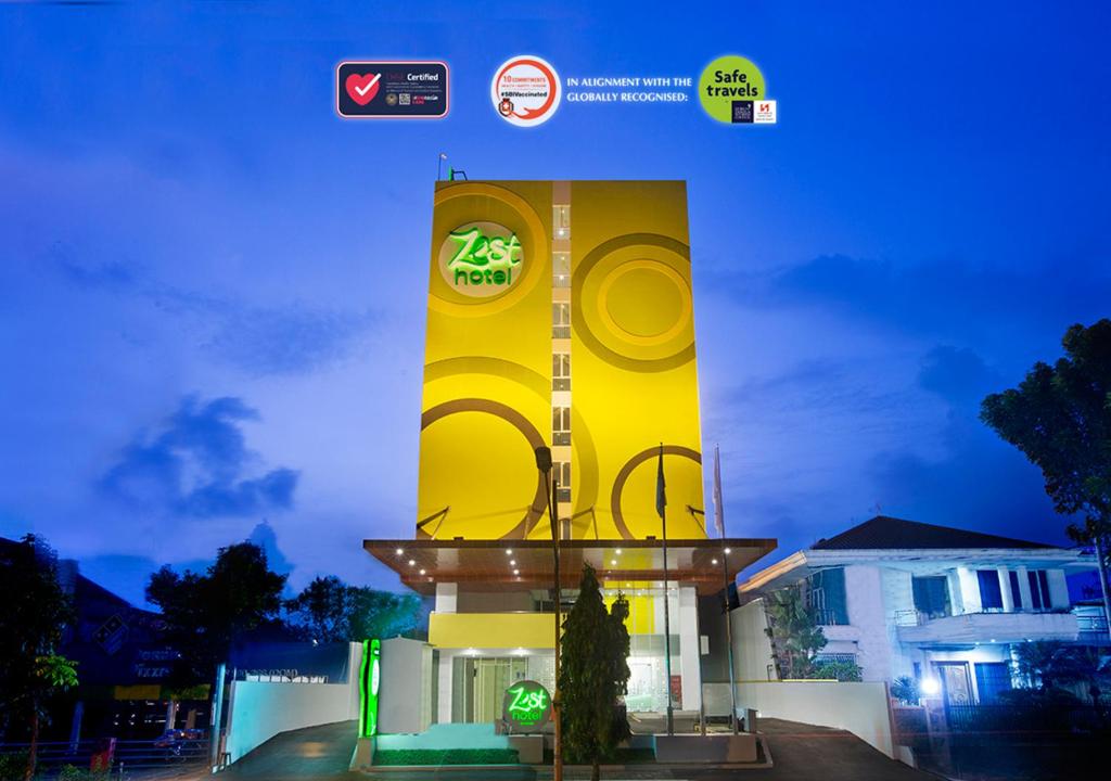um edifício amarelo com um relógio à noite em Zest Bogor by Swiss-Belhotel International em Bogor