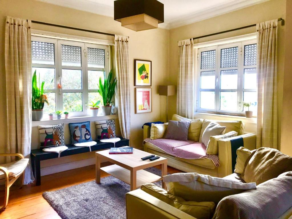salon z 2 kanapami i 2 oknami w obiekcie Antas Cozy House w Porto
