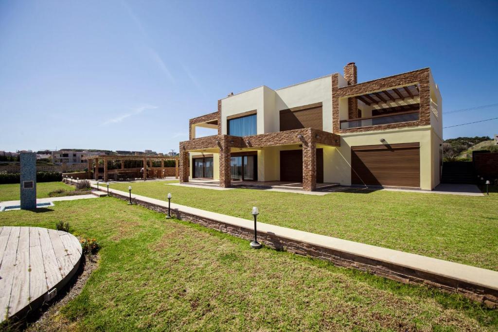 a house with a large lawn in front of it at Private beach villa Princess in Kiotari