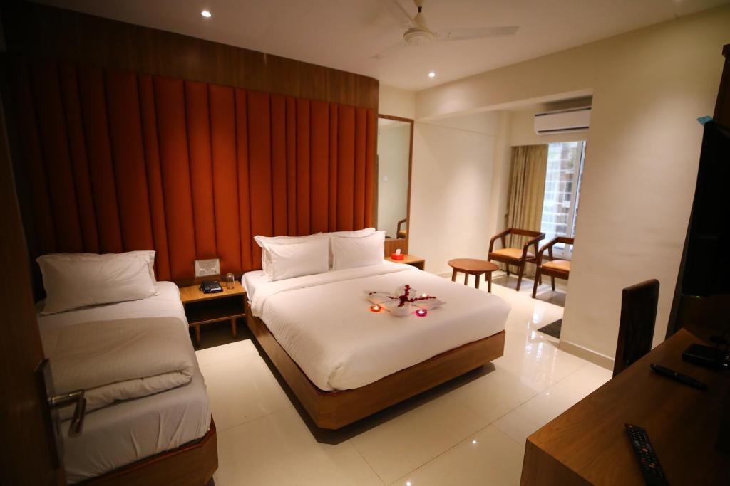 Habitación de hotel con 2 camas y sala de estar. en Hotel Dream Residency en Navi Mumbai