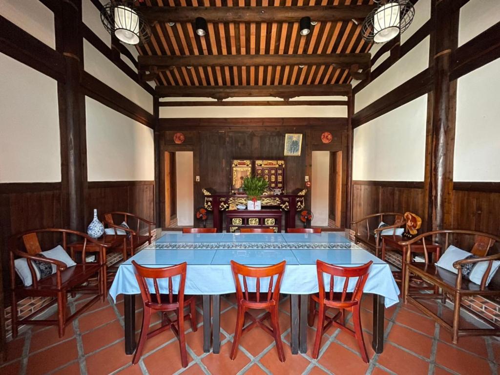 uma sala de jantar com mesa e cadeiras em 金門古寧歇心苑官宅古厝民宿 Guning Xiexinyuan Historical Inn em Jinning