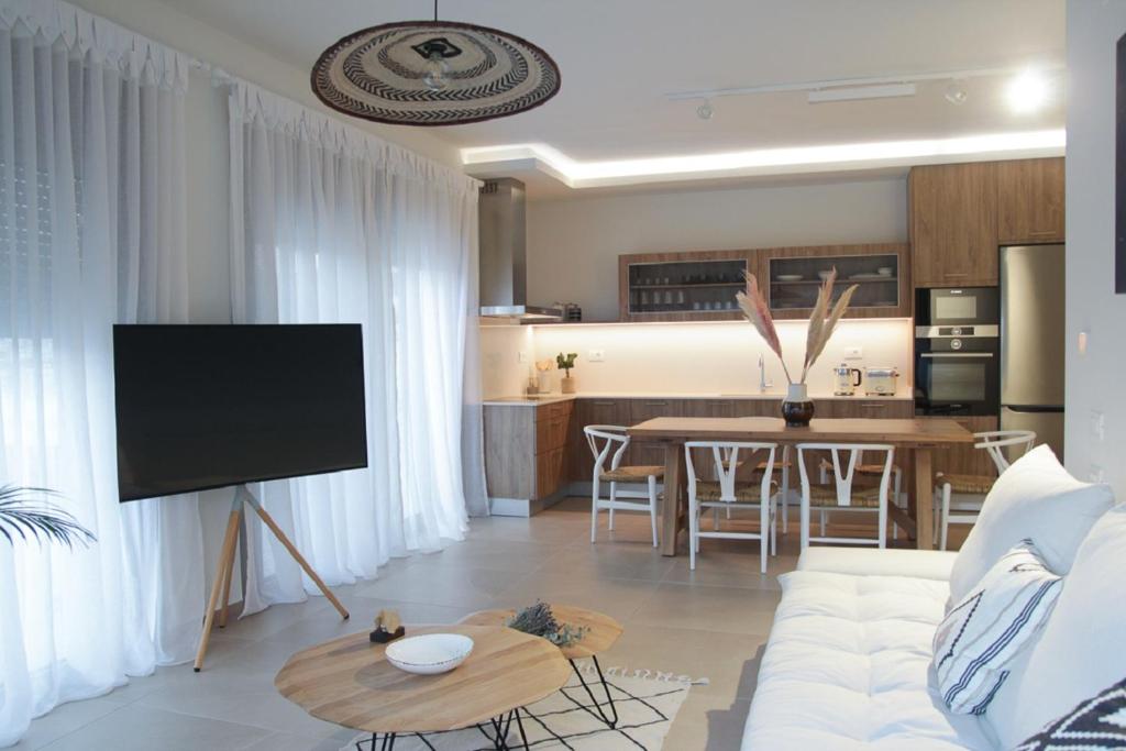 uma sala de estar com um sofá branco e uma mesa em Elounda Katikia Luxury Living em Elounda