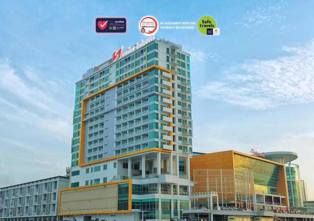 a tall building with a sign on top of it at Swiss-Belhotel Balikpapan in Balikpapan