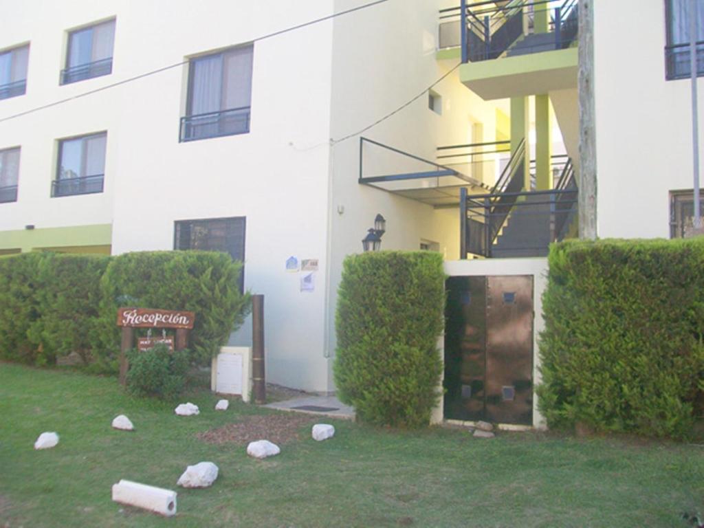 un edificio con rocas en el césped frente a un edificio en Pinares de Colon en Colón