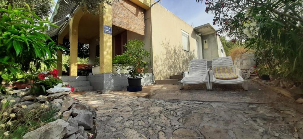 a pair of chairs sitting outside of a house at Holiday Home Zeljana in Kaprije