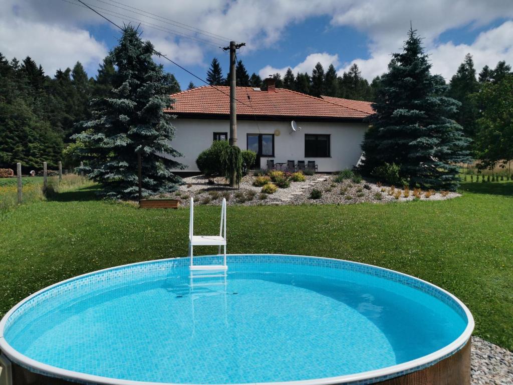 una piscina con una silla en un patio con una casa en U Waltera en Police nad Metují
