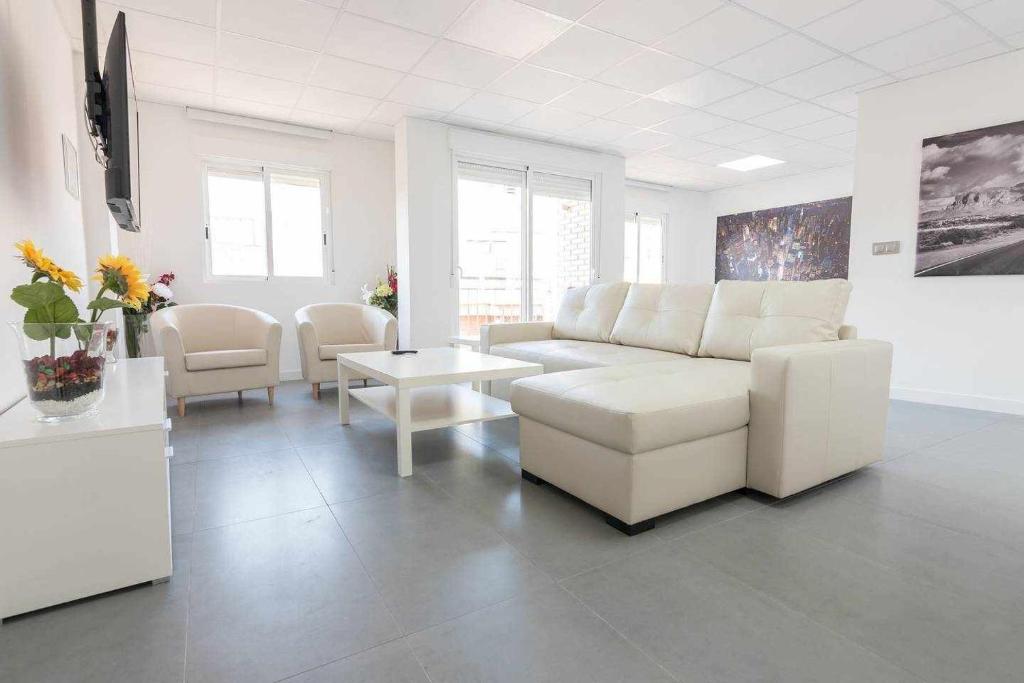 sala de estar con sofá blanco y sillas en Apartamento Céntrico Salzillo, en Murcia