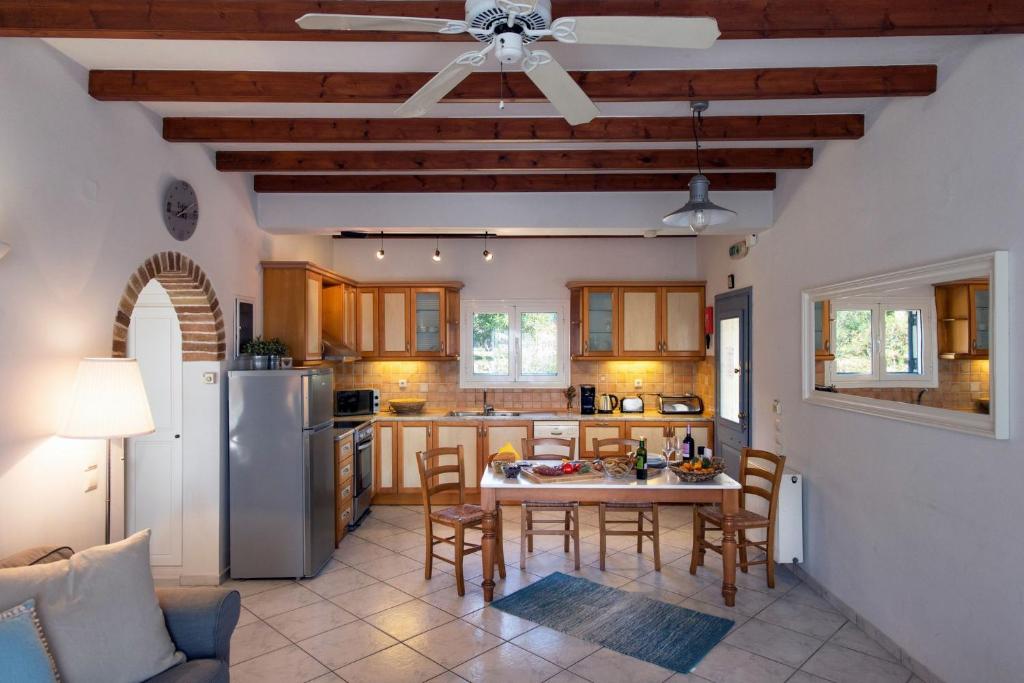 kuchnia ze stołem, krzesłami i lodówką w obiekcie Panorama Villas Corfu 3 Bedroom Villa Sea View With Private Pool w mieście Arillas